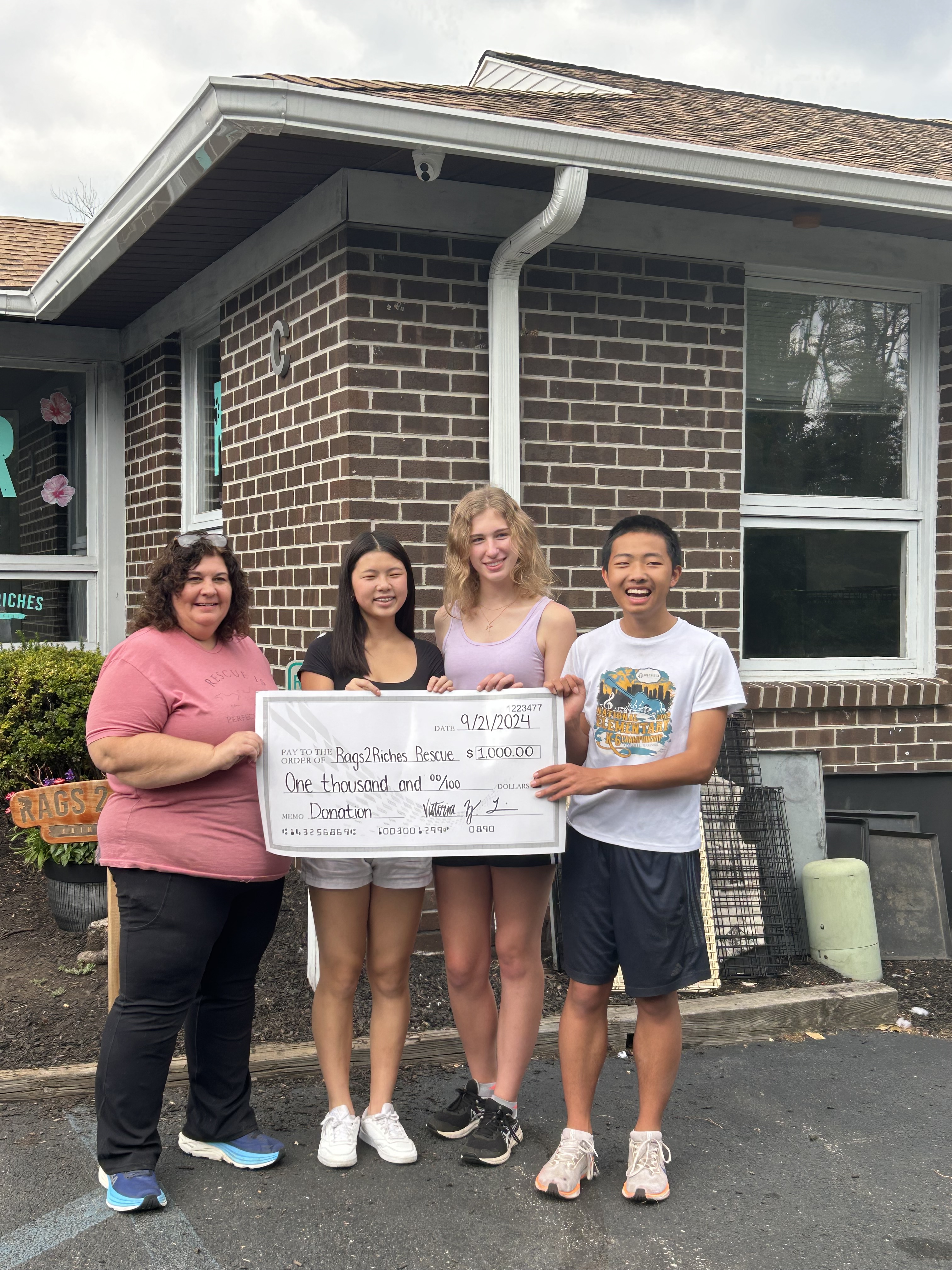 Adolescents for Animals members presenting a donation check to the local dog shelter, 2024