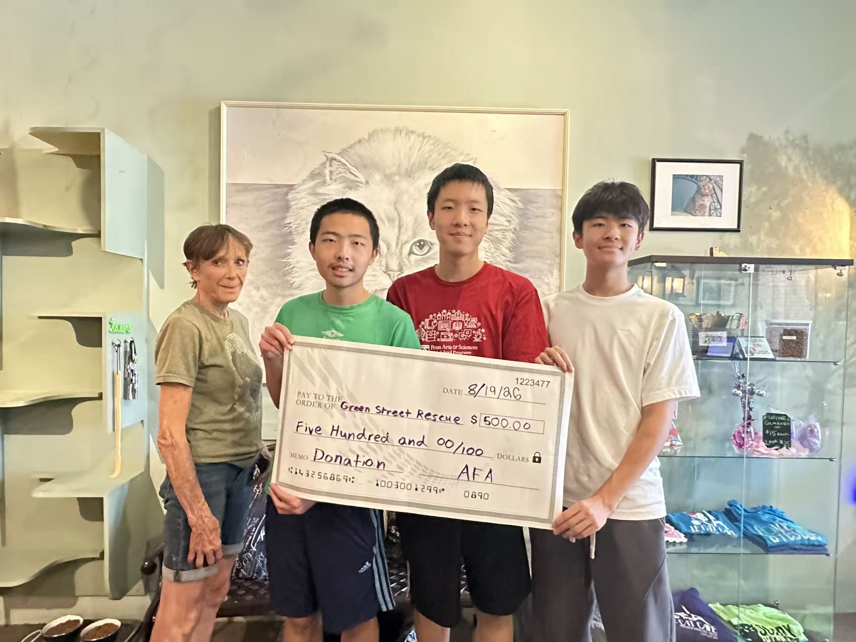 Adolescents for Animals members presenting a $500 donation check to Green Street Rescue at Le Cat Cafe, August 2026